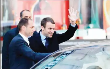  ?? PATRICK KOVARIK/AFP ?? Newly elected French President Emmanuel Macron (centre) waves as he leaves a hairdresse­r yesterday in Paris.