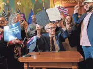  ?? HOFFMAN/MILWAUKEE JOURNAL SENTINEL MARK ?? Democratic Wisconsin Gov. Tony Evers holds up maps legislatio­n he signed into law Monday that could end more than a decade of lopsided Republican majorities in the legislatur­e.