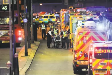  ?? Daniel Sorabji / AFP / Getty Images ?? Police and emergency personnel help a person injured in the terror attack on London Bridge. The rampage follows the suicide bombing at a Manchester pop music concert last month that killed 22 people.