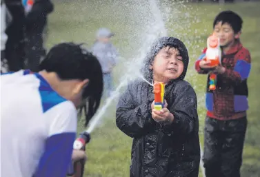  ?? Carlos Avila Gonzalez / The chronicle ?? Silas Naing (left) and Jacob Ho blast each other with squirt guns in the Myanmar New Year Water Festival.