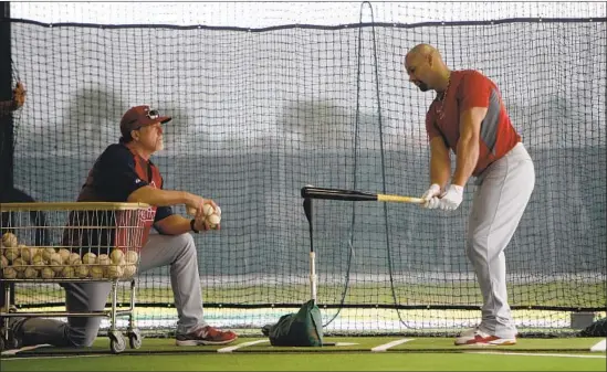  ?? Jeff Roberson Associated Press ?? ALBERT PUJOLS WORKS with St. Louis batting coach Mark McGwire during spring training in 2011. Pujols signed a 10-year deal with the Angels after the season.