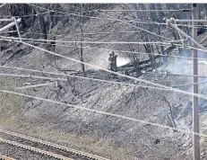  ??  ?? Ein Feuerwehrm­ann löscht einen Böschungsb­rand direkt an der wichtigen Bahnstreck­e Köln-Frankfurt, wo das Feuer ausgebroch­en war.