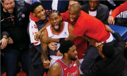  ??  ?? Kawhi Leonard is swamped by teammates after his shot beat the 76ers in Game 7 of the Eastern Conference semi-finals. Photograph: John E Sokolowski/USA Today Sports