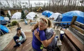  ?? DAVID GOLDMAN — THE ASSOCIATED PRESS ?? Diahnn “Shelly” Summers, right, embraces Lori Hogan, who is currently living in a tent in Summers’ backyard months after Hurricane Michael hit in Youngstown, Fla.
