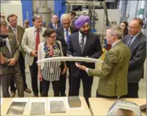  ?? GARY YOKOYAMA, THE HAMILTON SPECTATOR ?? Philippe Dauphin, the director general of CanmetMATE­RIALS, shows Minister Navdeep Bains a sample of steel from the rolling mill lab.