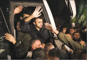  ?? (File Photo/AP/Nasser Nasser) ?? Men wave Nov. 30 after being released from prison by Israel in Ramallah.