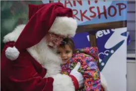  ?? ERIC BONZAR — THE MORNING JOURNAL ?? Two-year-old Kadence Swiger gets a hug from “Santa” during Metro PCS 225 E. 42nd St. location’s customer appreciati­on holiday party, Dec. 15.