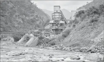  ??  ?? The Punatsangc­hu River runs past an industrial site located near the town of Wangdue Phodrang.