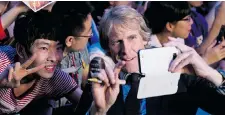 ?? ALEXANDER F. YUAN/ THE ASSOCIATED PRESS ?? The latest Transforme­rs movie, directed by Michael Bay, centre, seen in Beijing, has gone all-out to woo China’s massive movie-going audience.