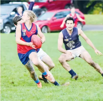  ??  ?? Trent Baker breaks away from his Catani pursuers as he turns to kick the ball into Buln’s forward line.