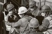  ?? Chen Hao / Associated Press ?? Rescuers carry a man who was trapped in a mine in the eastern Chinese province of Shandong on Sunday.