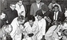  ?? CHARLES PUGH / AJC ?? Charlayne Hunter and Hamilton Holmes, the first black students at the University of Georgia, arrive on campus in January 1961 surrounded by reporters.