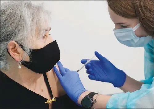  ?? (AP/Czarek Sokolowski) ?? Hanna Zientara, an 83-year-old resident of Warsaw, receives a covid-19 booster shot Tuesday in Warsaw, Poland.