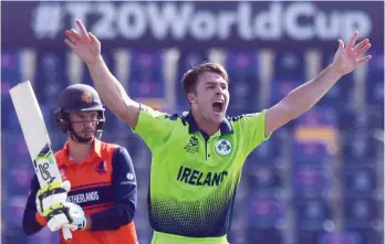  ?? — AFP ?? Ireland’s Curtis Campher (R) celebrates after taking the wicket of Netherland’s Scott Edwards during the ICC T20 World Cup match at the Sheikh Zayed Stadium in Abu Dhabi.