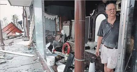  ?? JOE RAEDLE GETTY IMAGES ?? Mike Lindsey stands in his antique shop after the winds from hurricane Michael broke the windows.