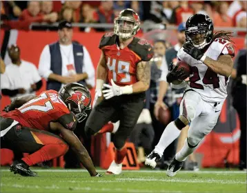  ?? AP PHOTO BY PHELAN M. EBENHACK ?? Atlanta Falcons running back Devonta Freeman (24) runs past Tampa Bay Buccaneers strong safety Keith Tandy, left, and linebacker Riley Bullough (49) for a 32-yard touchdown during the second half of an NFL football game, Monday in Tampa, Fla..