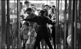  ?? MARK SCHIEFELBE­IN/THE ASSOCIATED PRESS ?? A security guard opens the entrance doors for the grand opening of an entertainm­ent complex Saturday at “Wanda City” in Nanchang in southeaste­rn China’s Jiangxi province.