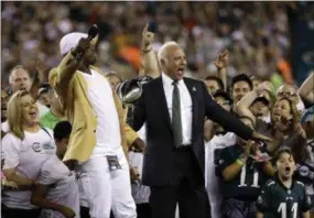  ?? MICHAEL PEREZ — THE ASSOCIATED PRESS ?? Eagles owner Jeffrey Lurie reacts alongside Brian Dawkins during a ceremony before the team’s game against the Falcons on Thursday.