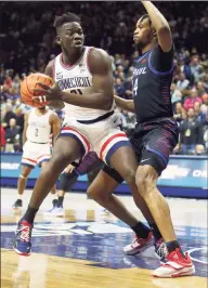  ?? Stew Milne / Associated Press ?? UConn’s Adama Sanogo, left, is defended by DePaul’s Nick Ongenda during the first half Saturday.