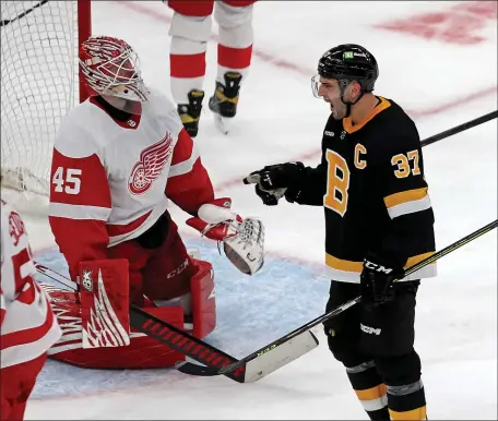  ?? STUART CAHILL — BOSTON HERALD ?? Bruins center Patrice Bergeron screams after scoring the tying goal as Detroit Red Wings goaltender Magnus Hellberg looks on Saturday afternoon. The Bruins rallied to capture a 3-2 victory.