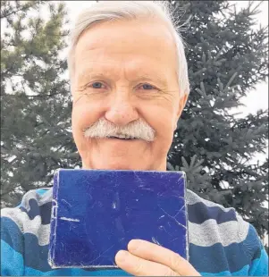  ?? CP PHOTO ?? Adrian Pearce holds an unopened Christmas gift. As Canadians tore open their presents this Christmas morning, there was one dog-eared gift that an Edmonton man won’t be opening that came from an old girlfriend who dumped him almost 50 years ago.