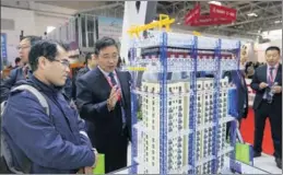  ?? WANG ZHUANGFEI / CHINA DAILY ?? A visitor looks at a green building model at the 16th China Internatio­nal Exposition of Housing Industry, Products and Equipment held in Beijing in October.