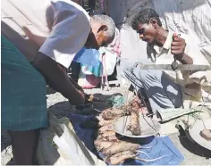  ??  ?? An Indian tea-tribe vendor sells cooked and uncooked rats at a weekly market in Kumarikata village along the Indo-Bhutan border, some 90km from Guwahati. Rat is at the top of the end-of-year holiday menu for crowds who flock to a market in northern India that specialise­s in rodents caught in local fields. — AFP photo