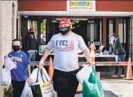  ?? Conn. Health I- Team ?? A man and boy leave the Domus Person to Person food pantry on Lockwood Avenue in Stamford.