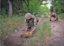  ?? The Associated Press ?? A Ukrainian special operations unit lays anti-tank mines on a forest road into Donetsk on Tuesday.