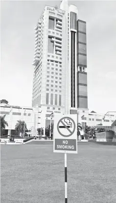  ??  ?? The ‘No Smoking’ signboard in front of Sibu Town Square Phase I, where Sarawak’s tallest building – the 126m Wisma Sanyan – looms.