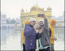  ?? SAMEER SEHGAL/HT ?? Devotees taking a selfie at the Golden Temple in Amritsar on Tuesday.