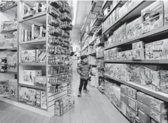  ?? Richard Drew, The Associated Press ?? A young customer checks out the merchandis­e Monday at Mary Arnold Toys in Manhattan’s Upper East Side.