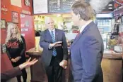  ?? CHRIS O’MEARA/AP ?? Vice President Mike Pence gestures as he speaks with Florida Gov. Ron DeSantis after ordering lunch May 20 at Beth’s Burger Bar in Orlando.