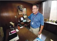  ??  ?? Roy Otto, city manager of Greeley, holds up a trophy awarded the city for its water July 26 as he jokes with reporters in his office in city hall.