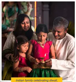  ??  ?? Indian family celebratin­g diwali, fesitval of lights inside a temple