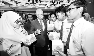  ??  ?? Najib shares a light moment with SMK Bandar Riching and SMK Sungai Pusu Gombak students after launching the 500 million additional units for AHB. — Bernama photo