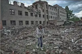  ?? Aris Messinis/Getty Images north america/Tns ?? A woman walks past a destroyed administra­tion building in the city of Bakhmut in the eastern Ukranian region of Donbas, on May 25, 2022.