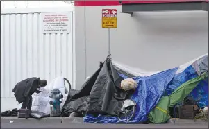  ?? The Associated Press ?? HOMELESS: A man stands near tents set up on a sidewalk Nov. 21 in San Francisco. When census takers tried to count the nation’s homeless population, they ran into many problems that could threaten the accuracy of the effort. That’s what a half dozen census takers around the U.S. tell The Associated Press.