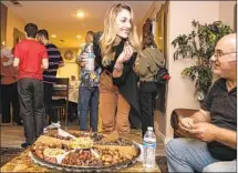  ?? Irfan Khan Los Angeles Times ?? AYA MUHTASEB and her father, Adnan Fejleh, break their fast with dates during Ramadan at a family gathering in Montclair.