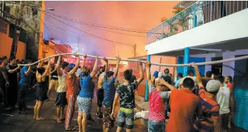  ?? PHOTOS AFP ?? Des résidents ont prêté main-forte aux pompiers mobilisés pour lutter contre le brasier qui s’est rapidement propagé dans ce quartier constitué d’habitation­s en bois.