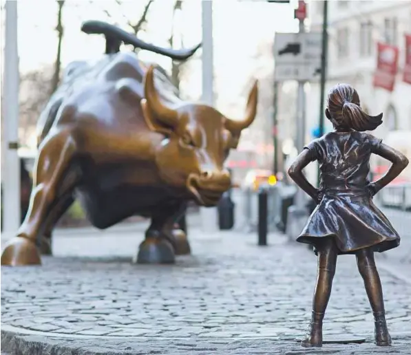  ?? AP ?? The Charging Bull and Fearless Girl statues on Lower Broadway in New York. Since 1989 the bronze bull has stood in New York’s financial district as an image of the hard-charging spirit of Wall Street. But the installati­on of the bold girl defiantly...