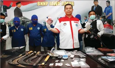  ?? GALIH COKRO/JAWA POS ?? HADAPI PERLAWANAN: AKBP Bagio Hadi menunjukka­n barang bukti beserta tersangka bandar narkoba di kantor BNNP kemarin.