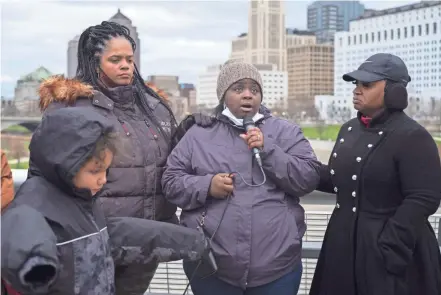  ?? ?? Malissa Thomas-st. Clair, left, founder of Mothers of Murdered Columbus Children, and Columbus Division of Police Assistant Chief Lashanna Potts, right, join Arnetta Davis at a ‘Locks of Love’ prayer vigil on the Rich Street bridge on Saturday. Davis represente­d the family of siblings Demetrius Wall-neal, 9 and Londynn Wall-neal, 6, who were fatally shot Tuesday in a triple homicide along with the mother’s boyfriend, Charles Wade, 22.