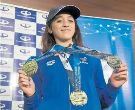  ??  ?? Reina del agua. Delfina Pignatiell­o y sus medallas en el Mundial Juvenil.