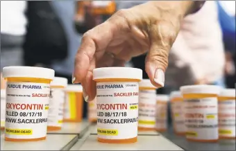  ?? Jessica Hill / Associated Press ?? Family and friends who have lost loved ones to OxyContin and opioid overdoses leave pill bottles in protest outside the headquarte­rs of Purdue Pharma, which is owned by the Sackler family, in August 2018 in Stamford.