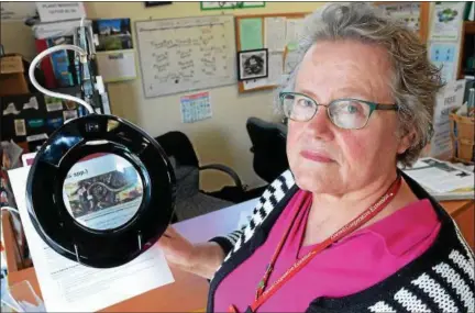  ?? TANIA BARRICKLO — DAILY FREEMAN ?? Cecily Frazier, a master gardener at the Cornell Cooperativ­e Extension, holds an image of a “jumping worm” beneath a magnifier at the extension’s Kingston Plaza location.