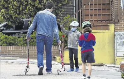  ?? DAVID CASTRO ?? Un padre acerca el patinete a sus hijos, ahora que están los colegios cerrados, en Madrid.