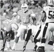  ?? JOE CAVARETTA/ STAFF PHOTOGRAPH­ER ?? Dolphins quarterbac­k Pat Devlin looks over the Saints’ defense in Thursday night’s preseason finale.