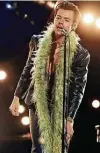  ?? Kevin Winter / AFP via Getty Images ?? Harry Styles performs in a leather suit, no shirt and a feather boa during the Grammy Awards.