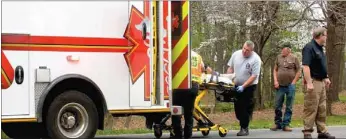  ?? TIMES photograph by Annette Beard ?? Emergency personnel load Kevin Lando into the ambulance as the Southwest Sanitation garbage truck driver, David Still, 63, watches. Police Chief Tim Ledbetter directs traffic. Lando, 18, of Pineville, Mo., was hit by a northbound truck on South Curtis...